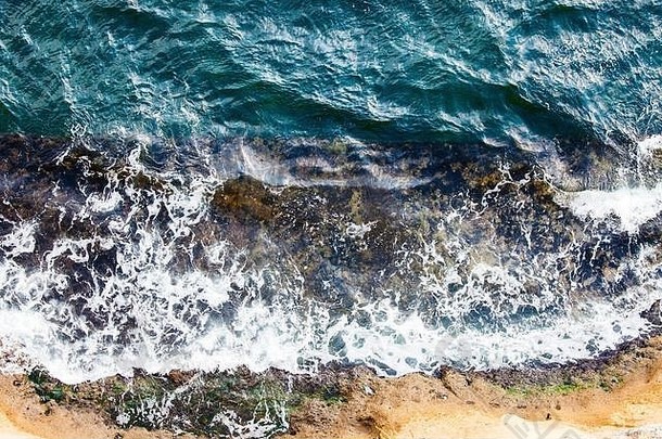 无人机俯瞰海岸，海浪冲击岩石。泡沫和飞溅物。<strong>深沉</strong>、强烈的颜色。