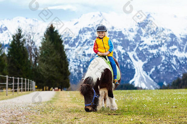 孩子们骑小马阿尔卑斯山脉山家庭<strong>春天</strong>假期马牧场奥地利蒂罗尔孩子们骑马孩子采取护理动物旗