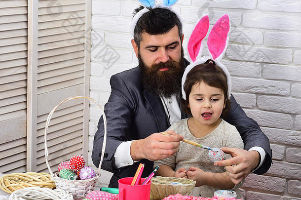 家人都喜欢复活节。在春假期间寻找鸡蛋。复活节快乐。童年父亲和女儿画复活节彩蛋。兔子一家有兔子耳朵。复活节美味佳肴