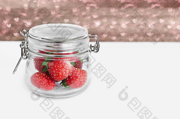 桌上一个玻璃罐里的草莓。