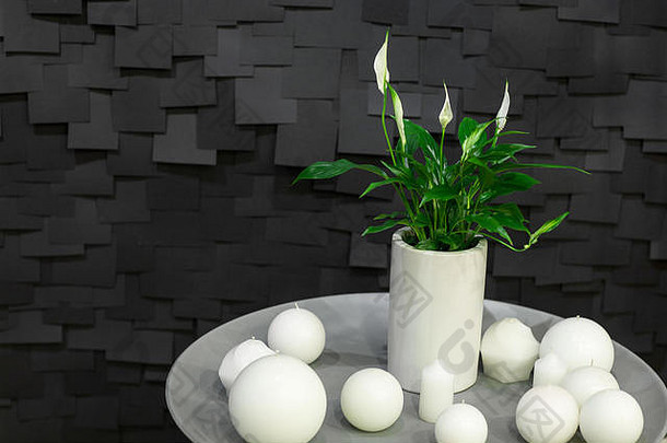 在深色背景上用瓷砖在白色盘子上装饰球状蜡烛和一个花瓶