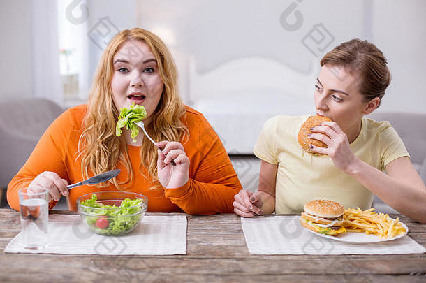 一个心满意足的胖女人和她的朋友一起吃午饭