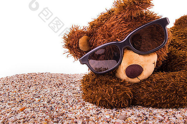 泰迪熊正在沙滩上晒日光浴