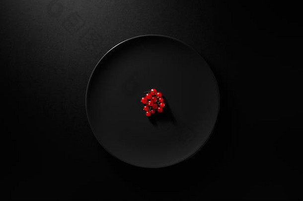 红色的醋栗服务黑色的板喜怒无常的黑色的背景健康的饮食开销视图