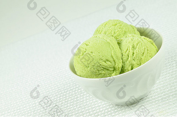 白色碗的特写镜头，三勺开心果冰淇淋，白色背景，水平，倾斜，宏观，细节