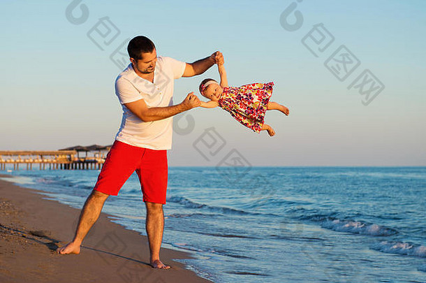快乐父亲玩可爱的女儿海滩