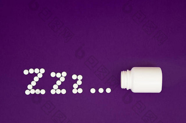 铭文zzz由药瓶溢出的白色药丸制成，背景为紫色