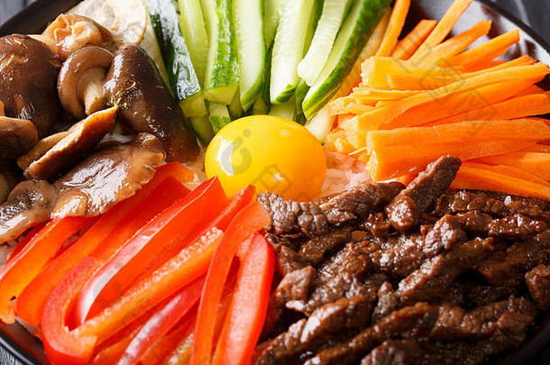 <strong>韩国料理</strong>：盘上放牛肉、生蛋黄、蔬菜和米饭。水平的