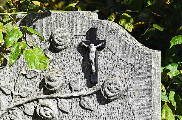 公共墓地墓碑上的十字架和花