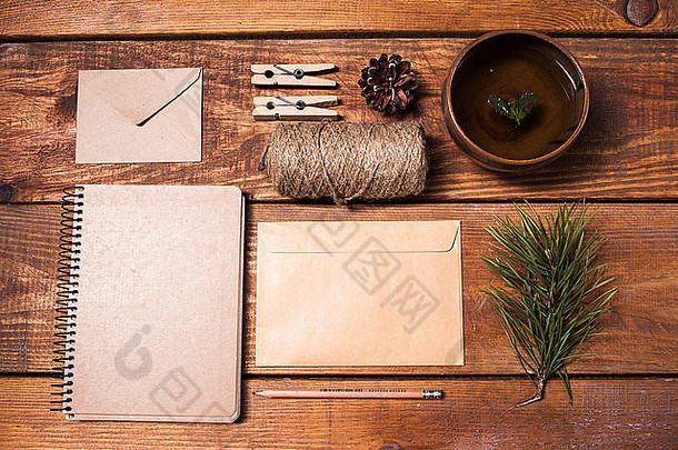 木制桌子上的食谱笔记本、无纸信封、绳子和衣夹。