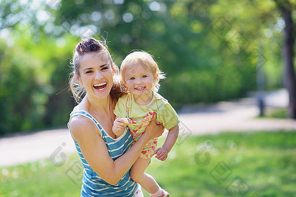 微笑妈妈。婴儿玩公园