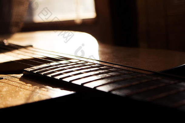 音乐工作室的原声吉他特写。在黄金时刻被太阳照耀着