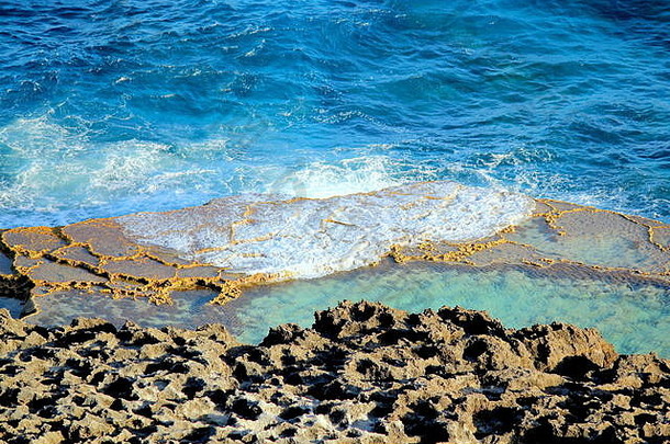 罗塔岛罗塔岛北马里亚纳群岛罗塔岛鸟类保护区脚下的珊瑚礁周围形成了一个岩石池，可供千人洗澡
