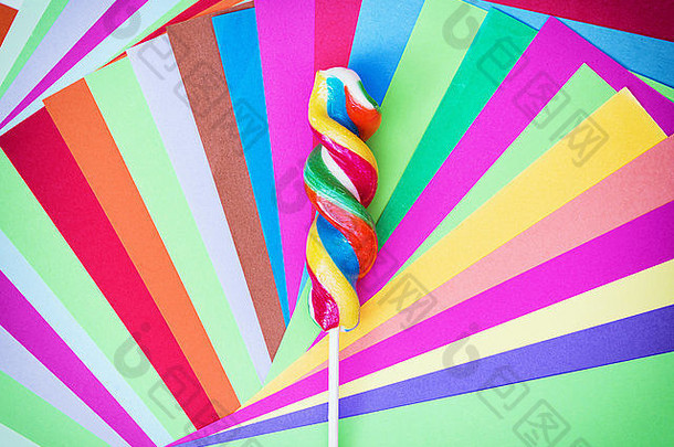 色彩斑斓的扭曲的甜蜜的棒棒糖明亮彩色的论文彩虹主题有趣的照片