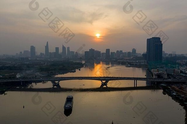 西贡河日落，空气污染严重。美丽的橙色、红色天空和越南胡志明市天际线的倒影。