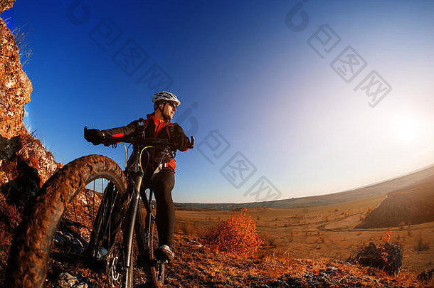 低角视图骑自行车的人骑山自行车岩石小道日出