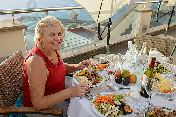这位老妇人在西班牙加那利群岛特内里费的洛斯吉甘特斯度假村的餐厅里吃着有食欲的晚餐。