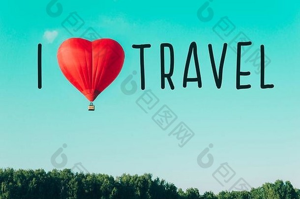 红色的热气球和心脏形状的云在蓝天的衬托下。爱与和平的概念。我喜欢旅游。