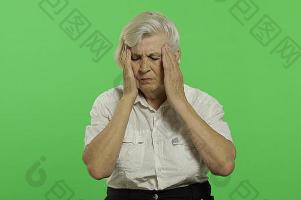 上了年纪的女人遭受头疼疼痛麻烦漂亮的祖母白色衬衫的地方标志文本浓度关键绿色屏幕背景概念情绪
