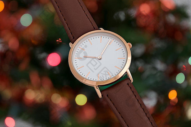 圣诞节期间在圣诞树灯光背景前的布朗皮表带腕表