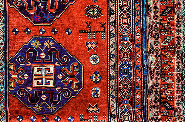 周日，埃里温市集上的纪念品<strong>清仓大</strong>拍卖会上，红色背景上印有风格化龙和驯鹿的古老亚美尼亚地毯