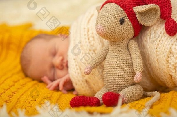 可爱的新生儿女孩睡觉针织背景特写镜头肖像鼠标玩具