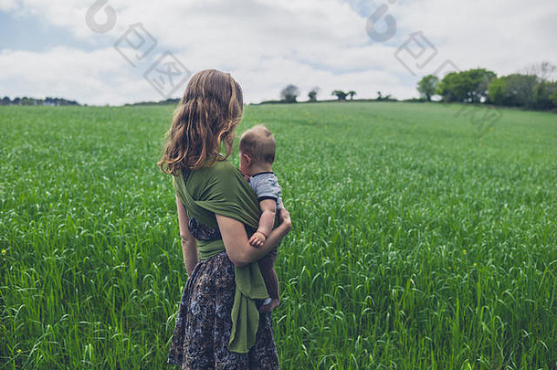 一位年轻的母亲和她的孩子站在草地上