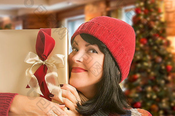 快乐的女人拿着包装好的圣诞礼物。