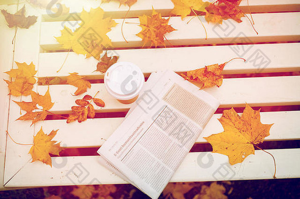 报纸咖啡杯板凳上秋天公园