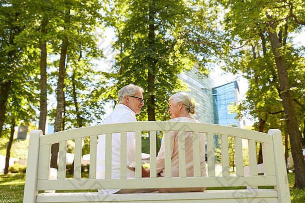 快乐的老年夫妇坐在公园的长椅上