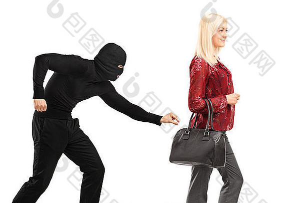 一个戴着面具的扒手试图从一名手持白色背景的钱包的妇女那里偷一个钱包