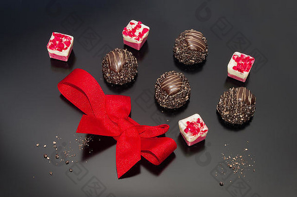 巧克力果仁糖装饰红色的邦博恩斯红色的系弓生日礼物婚礼订婚庆祝活动事件复活节概念背景