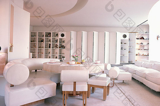 圆形混凝土桌和白色皮革家具，现代餐厅，白色屏风和架子