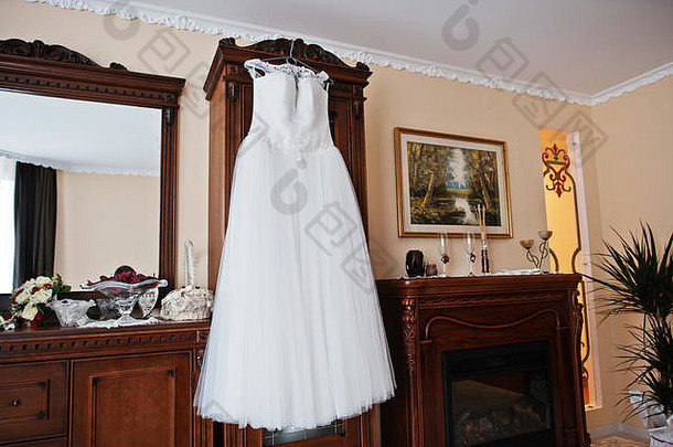 房间里新娘的白色婚纱挂在衣架上。