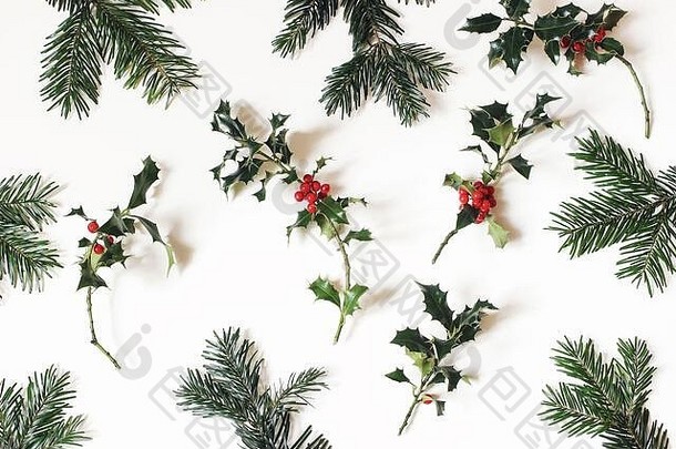 圣诞天然花卉图案。<strong>白</strong>色桌面背景上分离的红色冬青浆果和绿色冷杉树枝的组成。冬季自然