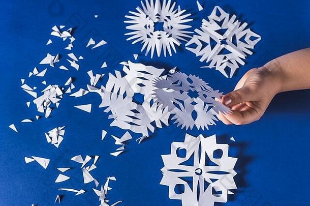 各种圣诞主题雪花的背景，在流行的蓝色背景上用白纸剪下