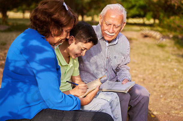 教育孙子的祖父母：老年妇女和老人在公园里陪孙子。老人们帮助老人