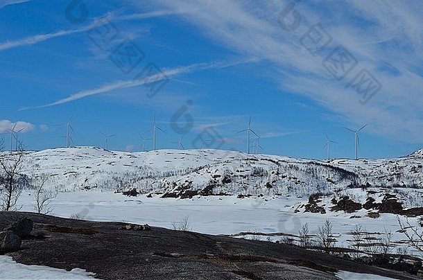 阳光明媚的冬天，雪山山顶上的风车公园