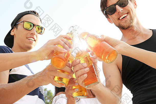 快乐的年轻朋友们在户外喝啤酒