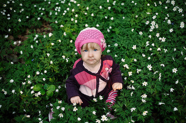 美丽的小女孩在花圃的森林里