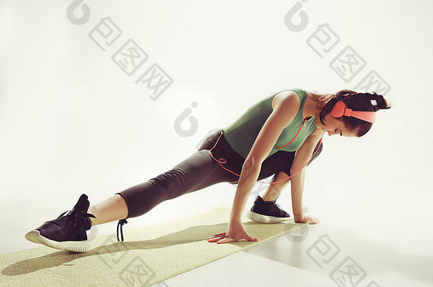 体操课上一名年轻女子伸展身体的前视图。