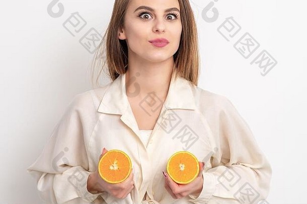 美丽的年轻的女人持有半橙子白色背景