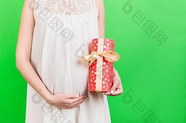 关闭肖像怀孕了女人白色衣服持有礼物盒子绿色背景怀孕庆祝活动复制空间