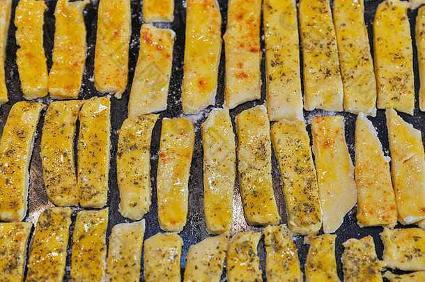 生面团、腌制奶酪、胡椒粉和普罗旺斯香草泡芙棒、烤箱托盘上的特写镜头