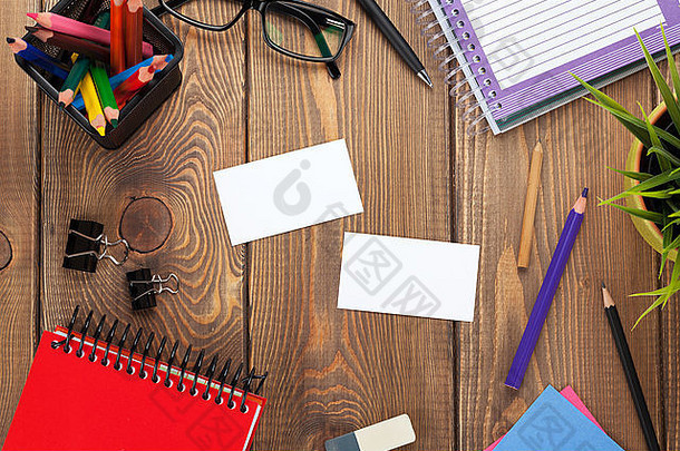 办公桌上有记事本、彩色铅笔、<strong>用品</strong>和<strong>名片</strong>。使用空间从上方查看