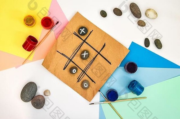 tic-tac-toe游戏的俯视图，石头上标记着零和十字架。儿童艺术项目，儿童手艺。DIY概念。一步一步地。