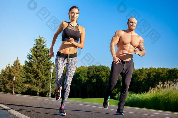 年轻强壮的男女健身模特在美丽的户外风景。在公园里奔跑的男人和女人