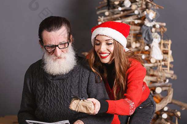 年轻的长头发的女儿红色的毛衣穿圣诞老人他微笑圣诞节礼物有胡子的高级爸爸穿眼镜灰色的毛衣一年圣诞节假期记忆礼物<strong>购</strong>物折扣商店雪少女圣诞老人老人化妆发型<strong>狂欢</strong>节