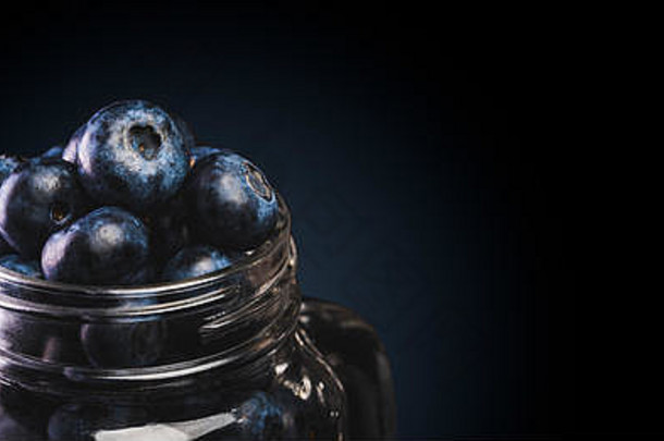 蓝莓玻璃Jar孤立的黑色的背景复制空间