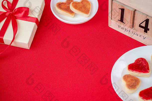 情人节背景。红丝带礼品盒，红色背景，心形蛋糕。假期背景。